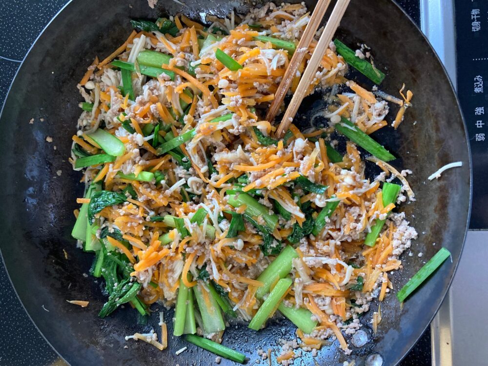 フライパンでそぼろと野菜を炒めるジューシーそぼろと野菜のビビンバの調理風景